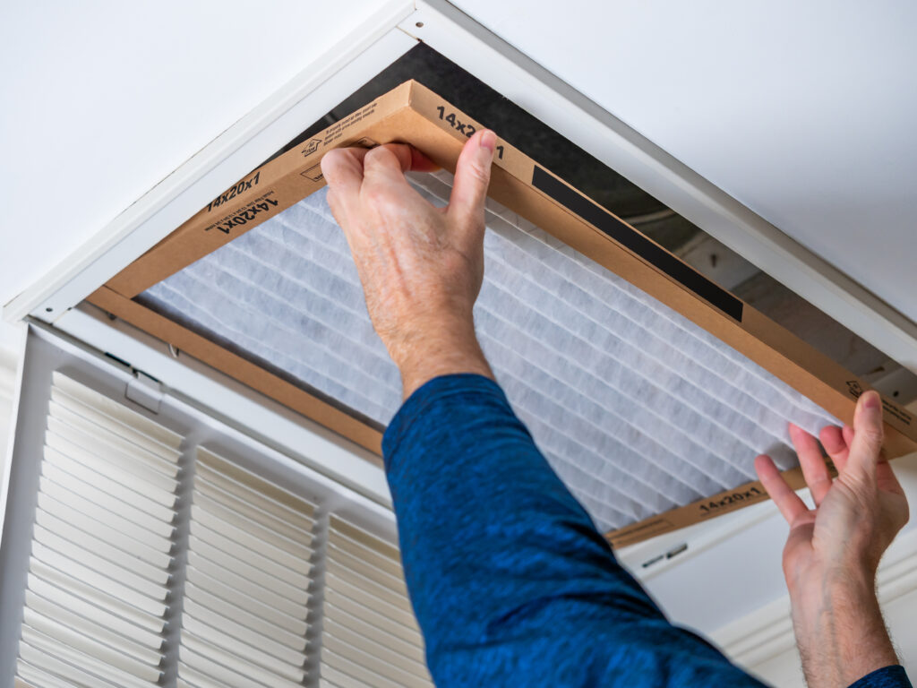 HVAC technician replacing a home air filter in Woodland
