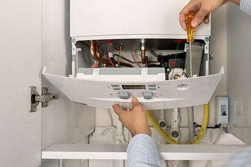 Heating technician repairing a residential boiler in Woodland