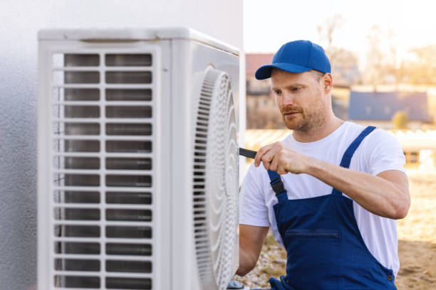 HVAC technician servicing an outdoor air conditioner in Woodland